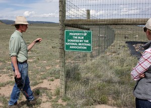 Ben Masters checks out the NMA/CO sign on the water catchment in Spring Creek Basin with wife Katie. Chrome's band is beyond.